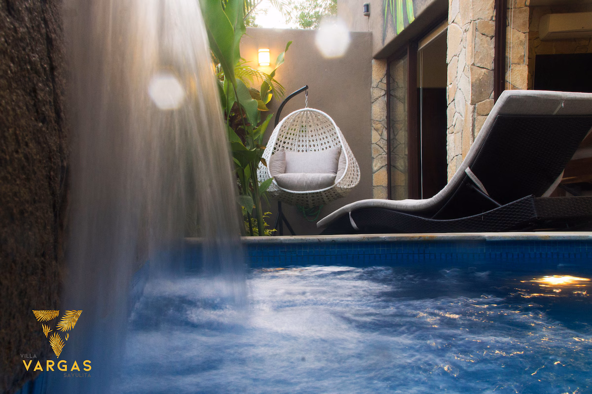 Private plunge pool with waterfall feature and lounge seating at Villa Vargas Sayulita