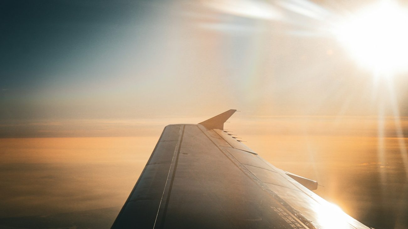The wing of an airplane as the sun shines through the clouds — Puerto Vallarta Airport to Sayulita
