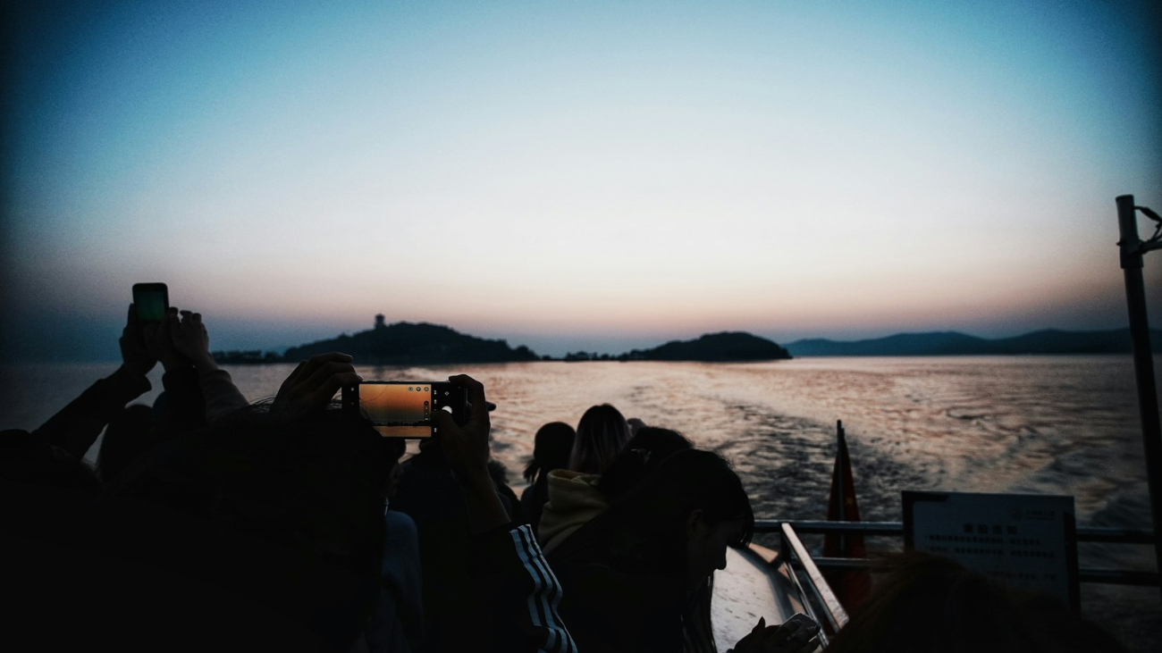 A group of friends on a boat watching the sunset, celebrating a milestone birthday trip near Sayulita