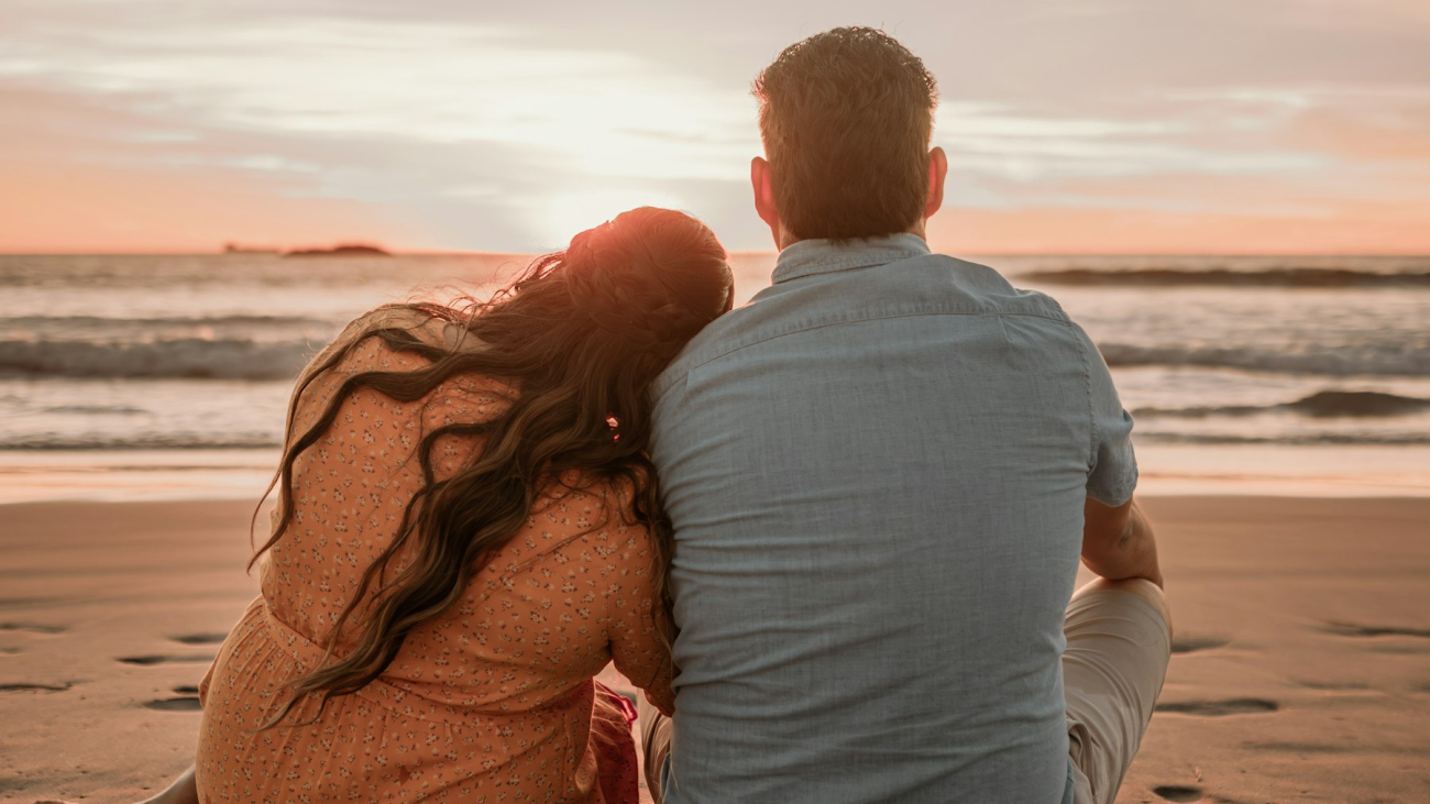 Couple sitting on the beach watching the sunset, a Sayulita honeymoon moment