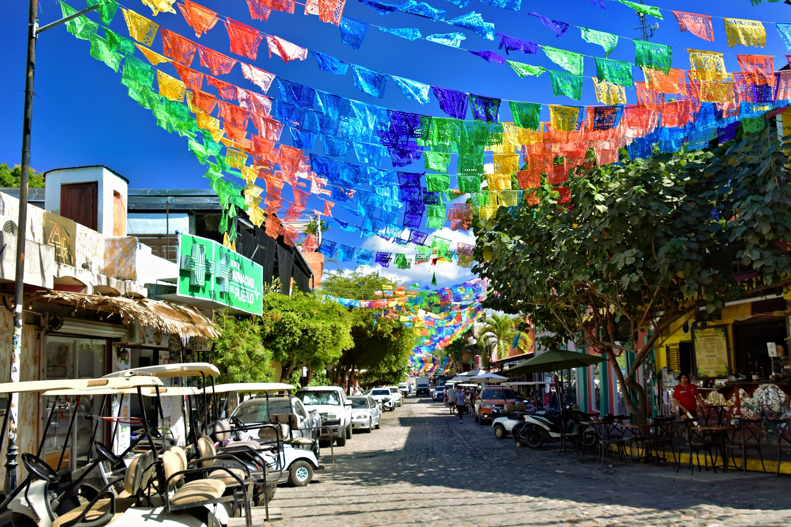 Papel picado strung above a colourful street in Sayulita, a Pueblo Magico