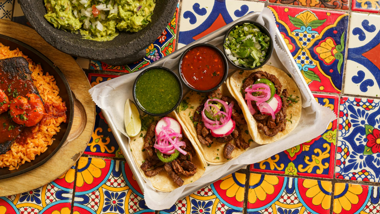A table topped with plates of Mexican food and a bowl of guacamole, best restaurants in Sayulita