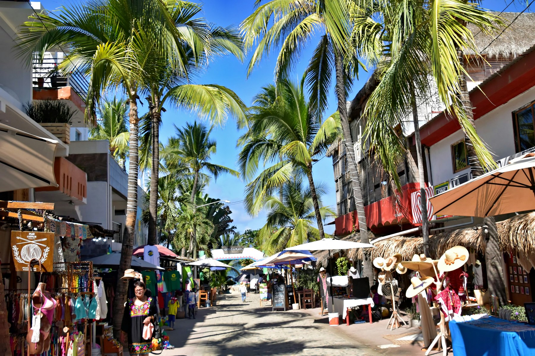 A Sayulita street lined with shops and palm trees